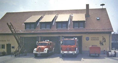 Das fertige Feuerwehrhaus mit Fahrzeugen, TSA und Leiter 1985.JPG